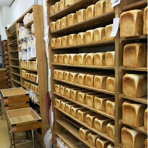 パンのペリカンの棚に並べられた大量の食パン